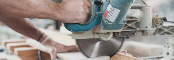 Person sägt Holz mit Kappsäge